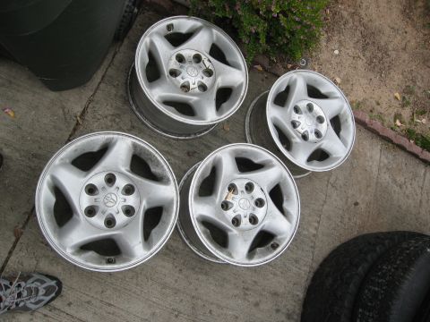 1986 Ford Bronco - These four aluminum alloy wheels, each a Toyota logo, are displayed on a concrete surface.