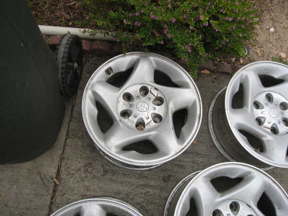 Several silver alloy wheels with a five-spoke design and a Toyota logo in the center