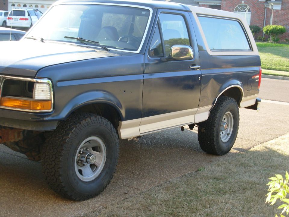 Dark blue Ford Bronco with tan lower trim in a driveway