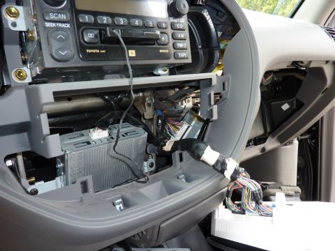 2002 Toyota Sequoia - Interior view of a 2002 Toyota Sequoia with the radio assembly removed, revealing the wiring harness and dashboard components.