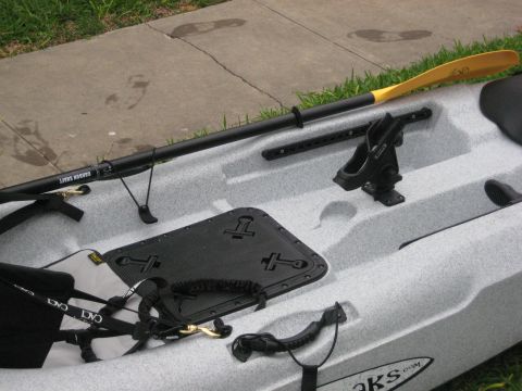 1953 Ford Mainline - A kayak and paddle are laid out on a concrete surface next to grass.