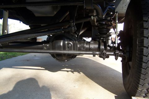 1990 Ford Bronco - A close-up view of the vehicle's undercarriage, revealing mechanical parts and suspension system.