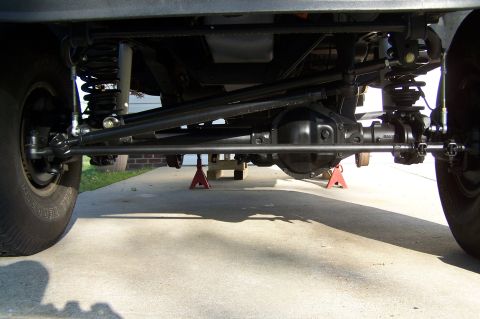 1990 Ford Bronco - Close-up view of a vehicle's undercarriage, showing mechanical parts and tires.