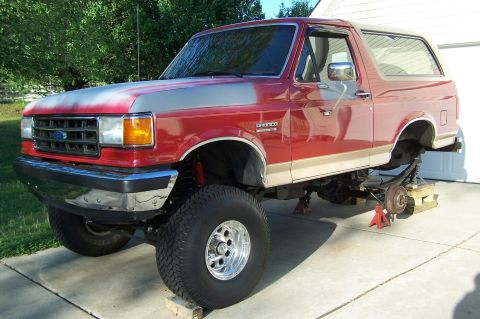 1990 Ford Bronco - This lifted SUV is shown from a 3/4 front angle.