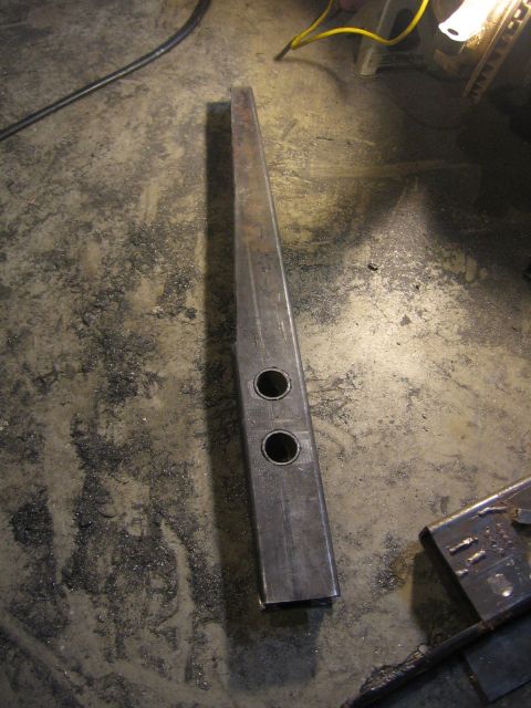 1989 Ford Bronco - A metal bracket with two holes is shown on a concrete floor.