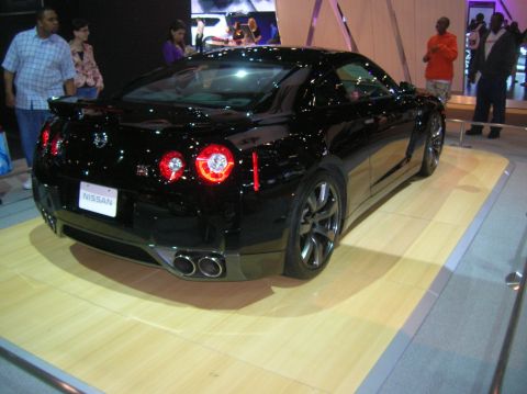 1996 Ford Bronco - A black Nissan GT-R is displayed on a wooden platform with people in the background.