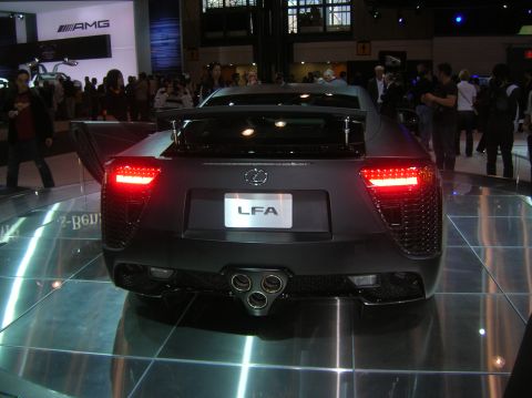 1996 Ford Bronco - The rear of a Lexus LFA is displayed with its distinctive triple exhaust pipes and illuminated taillights.