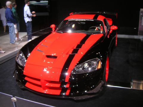 1996 Ford Bronco - A red and black Dodge Viper is displayed indoors with people observing it.