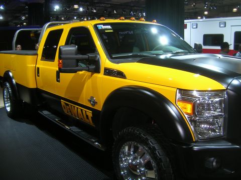 1996 Ford Bronco - A yellow and black DeWalt branded pickup truck is displayed indoors, possibly at a show.