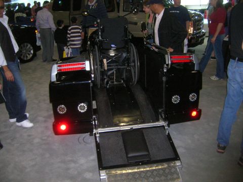 1996 Ford Bronco - A black conversion van is shown with its rear wheelchair lift extended, ready for use.