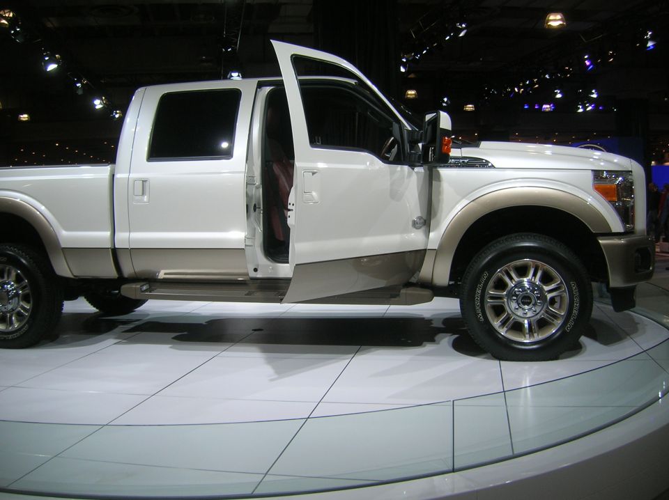 White and tan Ford F-Series truck with doors open, on display