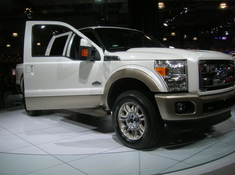1996 Ford Bronco - This white and tan pickup truck is displayed with its doors open, revealing its interior.