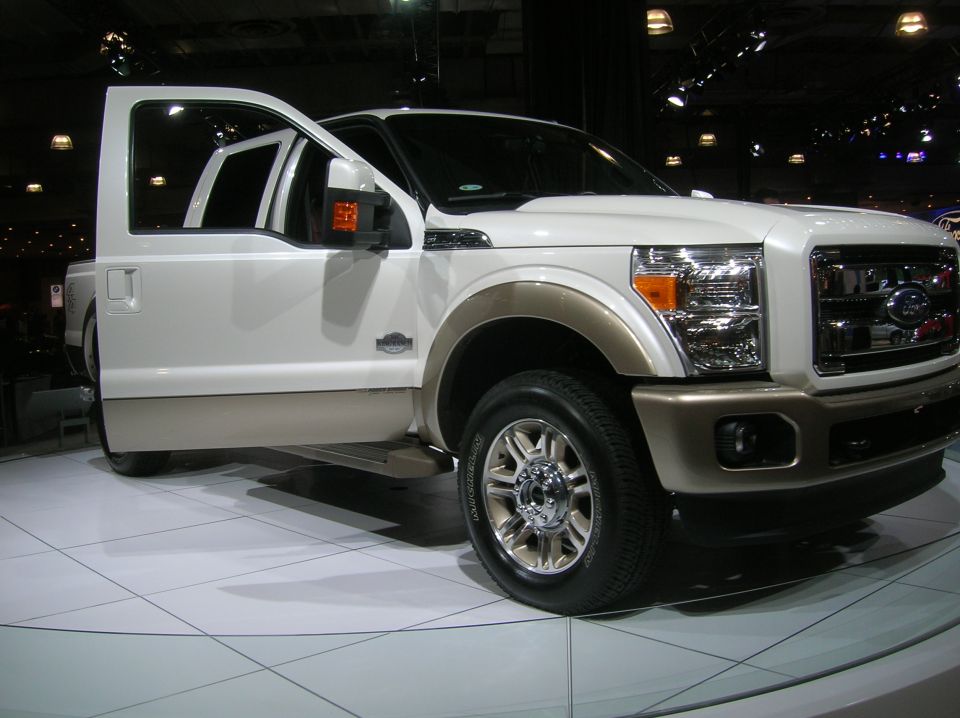 White and tan pickup truck, front 3/4 view with doors open