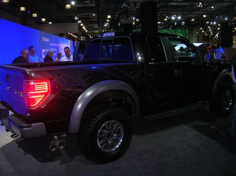 1996 Ford Bronco - A black pickup truck is displayed at an auto show, viewed from the rear three-quarter angle.