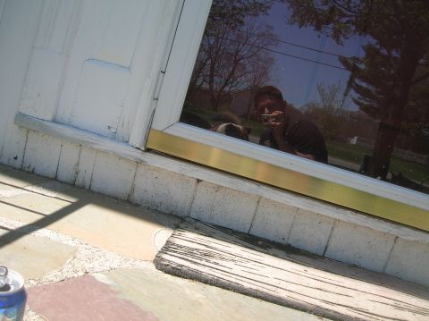 1996 Ford Bronco - A person and a dog are reflected in a window, with trees and sky visible in the background.