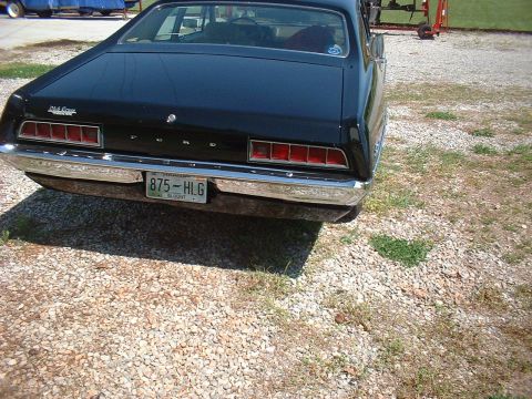 1970 Ford Falcon - The rear of a black 1970 Ford Falcon is shown, parked on a gravel surface.