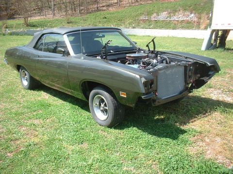 1970 Ford Torino - A 1970 Ford Torino convertible sits on grass with its hood open, revealing the engine compartment.