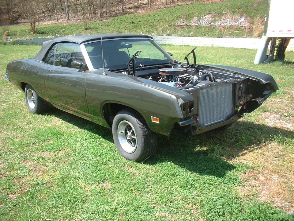 Dark green 1970 Ford Torino convertible with hood open, showing engine and radiator