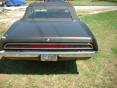 1970 Ford Torino - Rear view of a 1970 Ford Torino convertible with a black top, parked on a grassy area.
