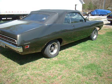 1970 Ford Torino - This 1970 Ford Torino convertible is viewed from the rear three-quarter angle, its dark green paint and black soft top.