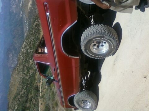 1978 Ford Bronco - 1978 Ford Bronco parked on a dirt road with mountains in the background.