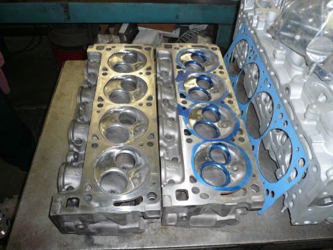 1975 Ford Ranchero - Engine cylinder heads and a gasket are laid out on a metal surface.