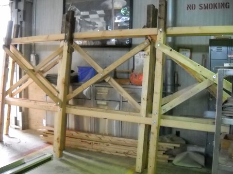 1986 Ford Bronco - A wooden frame structure is set up in a workshop area with various items in the background.