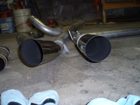2002 Chevrolet Camaro - Dual chrome exhaust tips are shown in a garage setting.