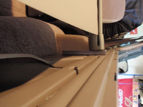 1995 Ford Bronco — Tan interior trim and fabric seats inside a vehicle, with a metal bracket visible