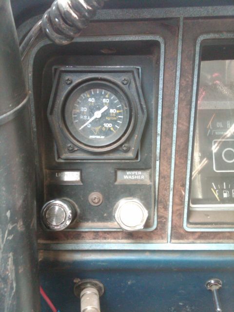 1978 Ford Bronco - Interior view of a vehicle's dashboard, showing a pressure gauge and control switches.