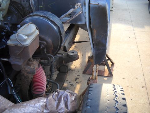 1954 Ford F-100 - Vehicle's brake booster and suspension parts are visible, with the vehicle supported by jack stands.
