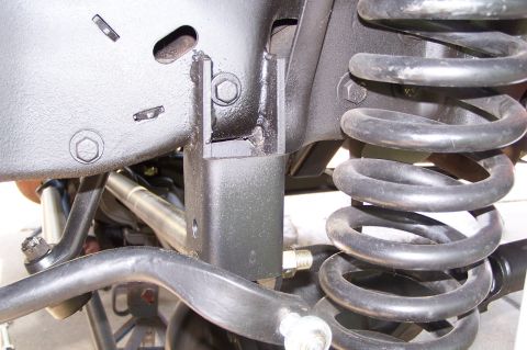 1990 Ford Bronco - Detail shot of suspension components, including a coil spring and various brackets and linkages.