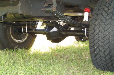 1990 Ford Bronco - Undercarriage view of a vehicle's rear axle and suspension system, showing leaf springs and shock absorbers.