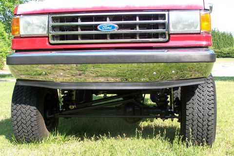 1990 Ford Bronco - Front view of a red 1990 Ford Bronco, showing its grille, headlights, and chrome bumper.