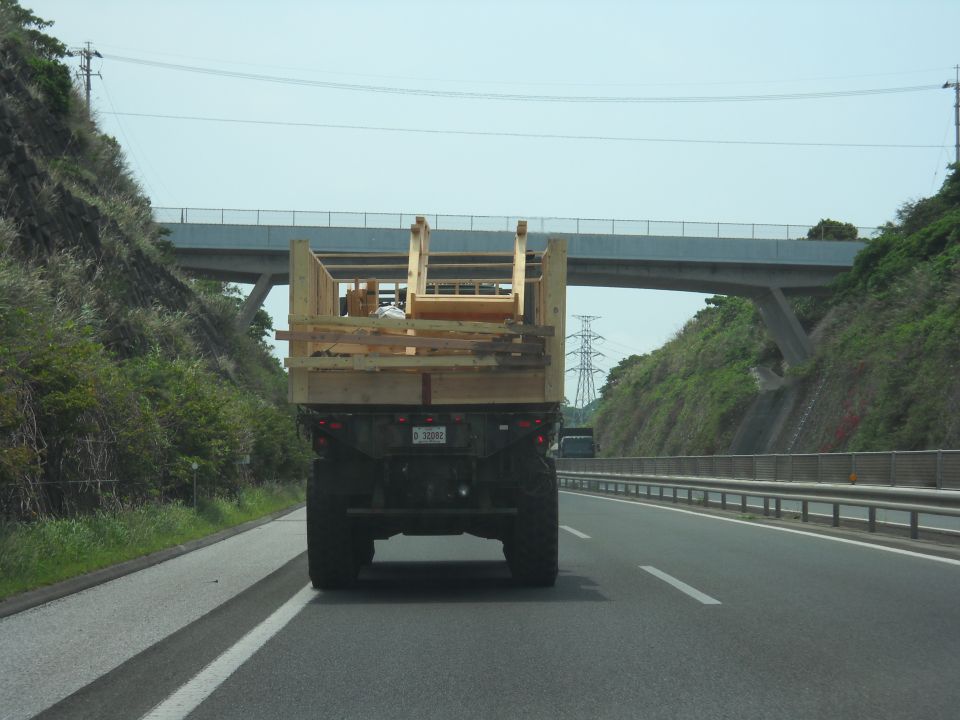 Rear view of military truck carrying wooden cargo on highway