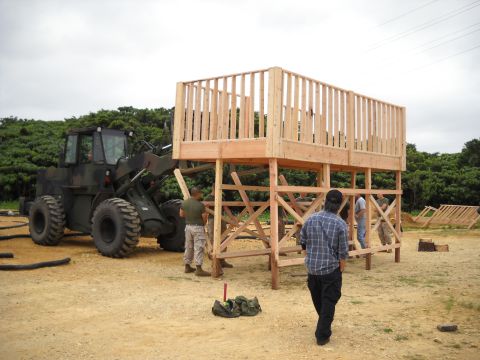 1986 Ford Bronco - A wheel loader is positioned near a partially built wooden observation deck, with workers present.