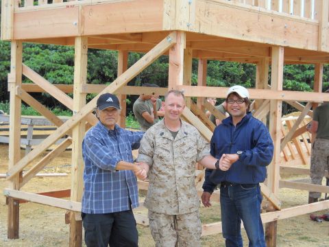 1986 Ford Bronco - Three men, including a US Marine, pose for a photo in front of a partially built wooden structure.