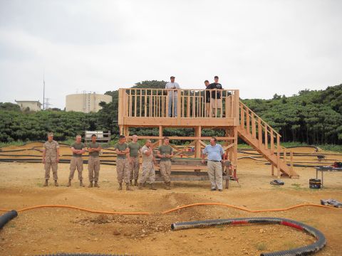 1986 Ford Bronco - A group of people stand around a newly constructed wooden observation deck at a remote control car track.
