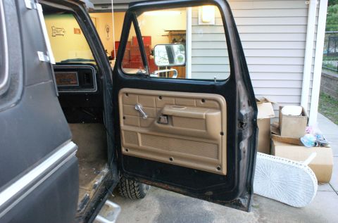 1979 Ford Bronco - View of the 1979 Ford Bronco's interior door panel and dashboard from the open driver's side door.