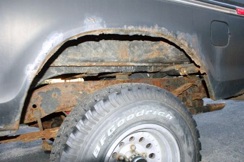 1979 Ford Bronco - The rear wheel well and frame of the vehicle show extensive rust and corrosion, indicating significant damage.