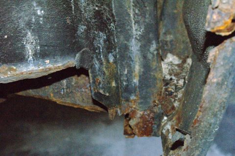1979 Ford Bronco - Close-up view of significant rust and damage to a vehicle's frame section, with a watermark for Supermotors.net.