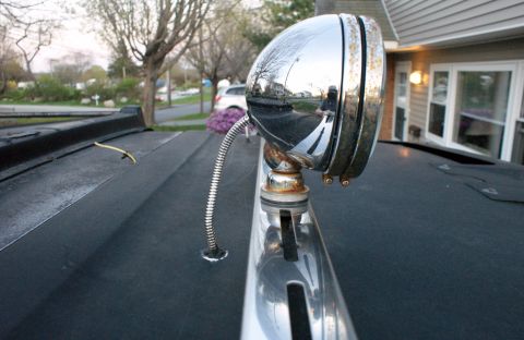 1979 Ford Bronco - Close-up of a chrome spotlight mounted on a vehicle's roof rack.