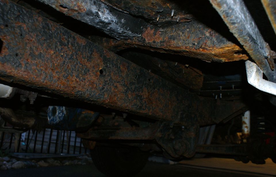 Heavily rusted frame and suspension components of a vehicle