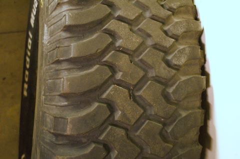 1979 Ford Bronco - The image shows a detailed view of an off-road tire's aggressive tread pattern, with some text visible on the sidewall.