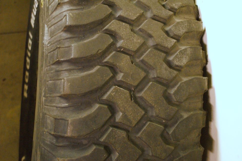 Close-up of a knobby off-road tire tread with 'RADIAL MUD' visible on the sidewall