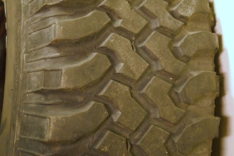 1979 Ford Bronco - A detailed view of a tire's aggressive tread pattern, showing significant wear and cracking.