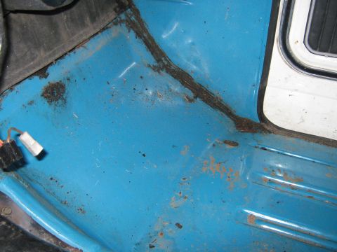1972 Ford F-250 - The interior floor of a truck shows signs of wear, rust, and dirt accumulation.