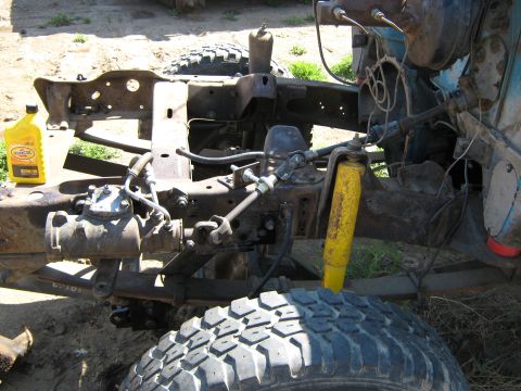 1972 Ford F-250 - The front end of a truck is disassembled, showing the steering gear, springs, and shock absorber.
