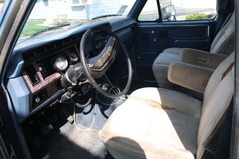1985 Ford F-350 - The interior of this truck shows its age with faded upholstery and a dated dashboard design.