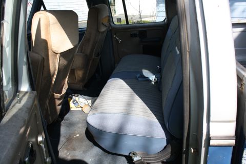 1985 Ford F-350 - The interior of a pickup truck, likely from the 1980s, shows worn seats and door panels.